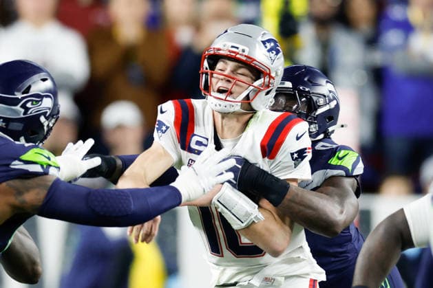 New England Patriots quarterback Drake Maye left, is hit by Seattle Seahawks defensive end DeMarcus Lawrence right, during the third quarter of Super Bowl LX at Levi s Stadium in Santa Clara, California on Sunday, February 8, 2026.  SBP20260208180 JOHNxANGELILLO
