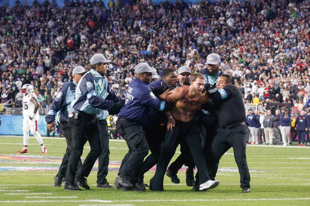 Security detains a fan that ran on the field during the fourth quarter of Super Bowl LX between the New England Patriots and the Seattle Seahawks at Levi s Stadium in Santa Clara, California on Sunday, February 8, 2026.  SBP20260208188 JOHNxANGELILLO
