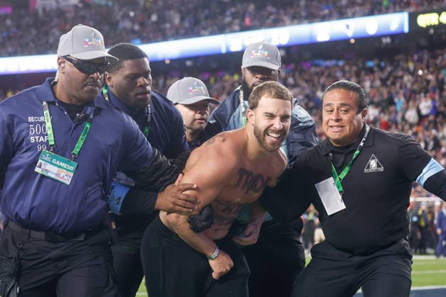 Security detains a fan that ran on the field during the fourth quarter of Super Bowl LX between the New England Patriots and the Seattle Seahawks at Levi s Stadium in Santa Clara, California on Sunday, February 8, 2026.  SBP20260208197 JOHNxANGELILLO