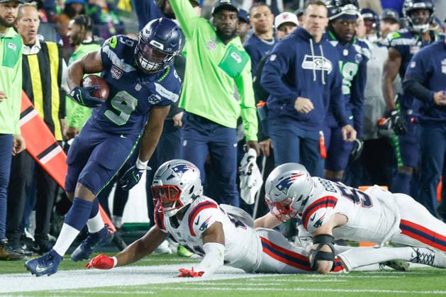 Seattle Seahawks running back Kenneth Walker III left, avoids New England Patriots safety Jaylinn Hawkins center, and New England Patriots linebacker Jack Gibbens right, during the fourth quarter of Super Bowl LX at Levi s Stadium in Santa Clara, California on Sunday, February 8, 2026.  SBP20260208202 JOHNxANGELILLO