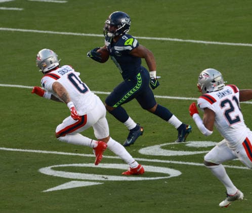 Seattle Seahawks running back Kenneth Walker III (9) sprints around New England Patriots cornerbac Christian Gonzales (0) and safety Jaylinn Hawkins (21)in the second quarter of Super Bowl LX at at Levi s Stadium in Santa Clara, California on Sunday, February 8, 2026.  SBP20260208608 JEDxJACOBSOHN