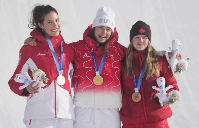 Gold medalist Mathilde Gremaud of Switzerland (C), silver medalist Eileen Gu of the People s Republic of China (L) and bronze medalist Megan Oldham of Canada stand on the podium after the Women s Freestyle Skiing Slopestyle final at the Milano Cortina 2026 Winter Olympic Games, Olympische Spiele, Olympia, OS in Livigno, Italy, on Monday, February 9, 2026.  OLY20260209801 BOBxSTRONG