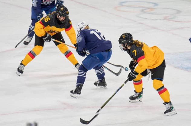 Jule Schiefer of Germany Franziska Feldmeier of Germany compete and fight for the puck against Estelle Duvin of France at the preliminary women Ice hockey, Eishockey match Group B Germany - France of the Milano Cortina 2026 Winter Olympic Games, Olympische Spiele, Olympia, OS at Milano Rho Ice Hockey Arena on February 9, 2026 in Milan, Italy.