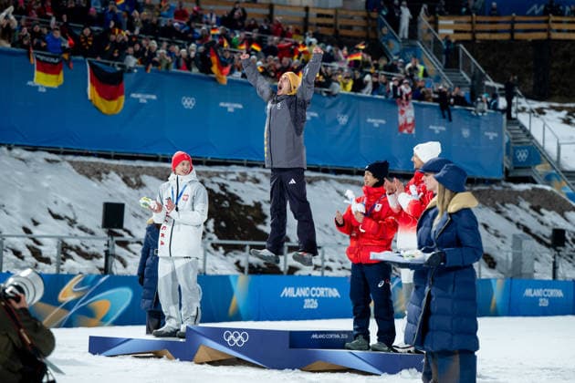 RAIMUND Philipp (Deutschland) jubelt auf dem Podium bei der Siegerehrungl ueber den Sieg und die Gold Medaille, dahinter Fans Zuschauer, daneben TOMASIAK Kacper (Polen), NIKAIDO Ren (Japan), DESCHWANDEN Gregor (Schweiz), ITA, Olympische Spiele Milano Cortina 2026, Olympia, Skispringen, Normalschanze Einzel Herren, 09.02.2026 ITA, Olympische Spiele Milano Cortina 2026, Olympia, Skispringen, Normalschanze Einzel Herren, 09.02.2026 Predazzo *** RAIMUND Philipp Germany cheers on the podium at the award ceremony about the victory and the gold medal, behind him fans spectators, next to him TOMASIAK Kacper Poland , NIKAIDO Ren Japan , DESCHWANDEN Gregor Switzerland , ITA, Olympic Games Milano Cortina 2026, Olympia, Ski Jumping, Normal Hill Single Men, 09 02 2026 ITA, Olympic Games Milano Cortina 2026, Olympia, Ski Jumping, Normal Hill Single Men, 09 02 2026 Predazzo Copyright: xEibner-Pressefoto Memmlerx EP_MMR