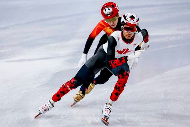 William Dandjinou of Canada and Xiaojun Lin of China Mixed Team Relay Quarterfinals, Milano Cortina 2026 Winter Olympics: Day 4, Short Track Speed skating, Eisschnelllauf - Milano Cortina 2026 Winter Olympics: Day 4, Milano Speed Skating Stadium, February 10, 2026, Milan, Italy.