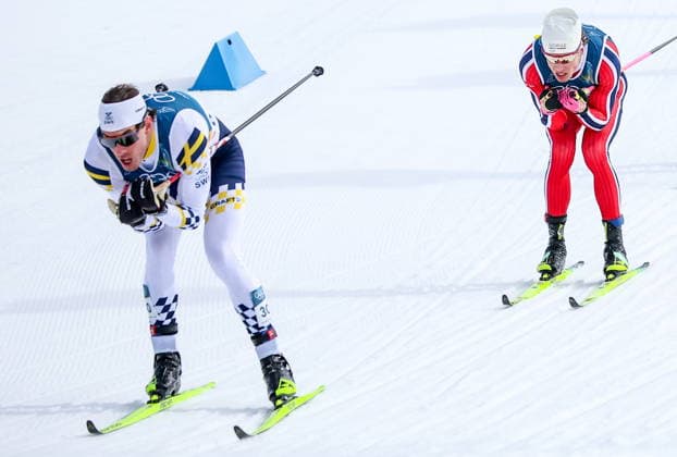 ITALY - FEBRUARY 10, 2026: Johan Haeggstroem of Sweden (L) and Johannes Hoesflot Klaebo of Norway compete in the men s cross-country skiing sprint classic quarterfinal at Tesero Cross-Country Stadium during the 2026 Winter Olympic Games, Olympische Spiele, Olympia, OS Peter Kovalev TASS  88476631