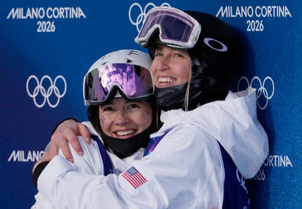 Elizabeth Lemley of the United States (L) hugs teammate Jaelin Kauf as they wait for the final skiing to finish in the Women s Freestyle Skiing Moguls Finals at the Milano Cortina 2026 Winter Olympic Games, Olympische Spiele, Olympia, OS in Livigno, Italy, on Wednesday, February 11, 2026. Lemley won the gold medal, Kauf won the silver medal and Perrine Laffont of France won the bronze medal..  OLY20260211893 BOBxSTRONG