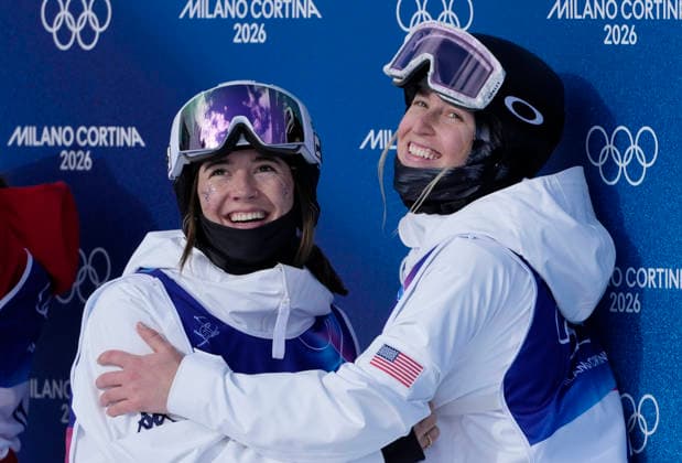 Elizabeth Lemley of the United States (L) hugs teammate Jaelin Kauf as they wait for the final skiing to finish in the Women s Freestyle Skiing Moguls Finals at the Milano Cortina 2026 Winter Olympic Games, Olympische Spiele, Olympia, OS in Livigno, Italy, on Wednesday, February 11, 2026. Lemley won the gold medal, Kauf won the silver medal and Perrine Laffont of France won the bronze medal.  OLY20260211896 BOBxSTRONG