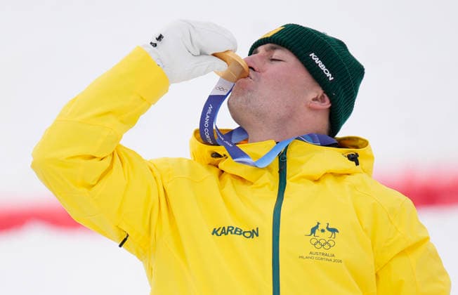 Gold medalist Cooper Woods of Australia kisses his medal after the Men s Freestyle Skiing Moguls competition at the Milano Cortina 2026 Winter Olympic Games, Olympische Spiele, Olympia, OS in Livigno, Italy, on Thursday, February 12, 2026. Mikael Kingsbury of Canada won the silver medal and Ikuma Horishima of Japan won the bronze medal.  OLY20260212807 BOBxSTRONG