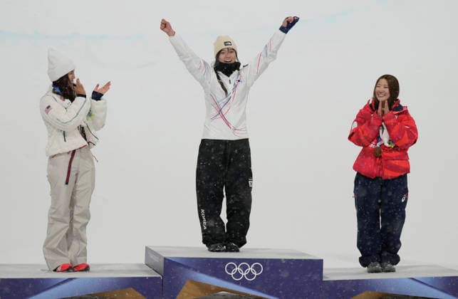 Gold medalist Gaon Choi of South Korea (C) is introduced on the podium as silver medalist Chloe Kim of the United States (L) and bronze medalist Mitsuki Ono of Japan applaud after the Women s Snowboard Halfpipe finals at the Milano Cortina 2026 Winter Olympic Games, Olympische Spiele, Olympia, OS in Livigno, Italy, on Thursday, February 12, 2026.  OLY20260212850 BOBxSTRONG
