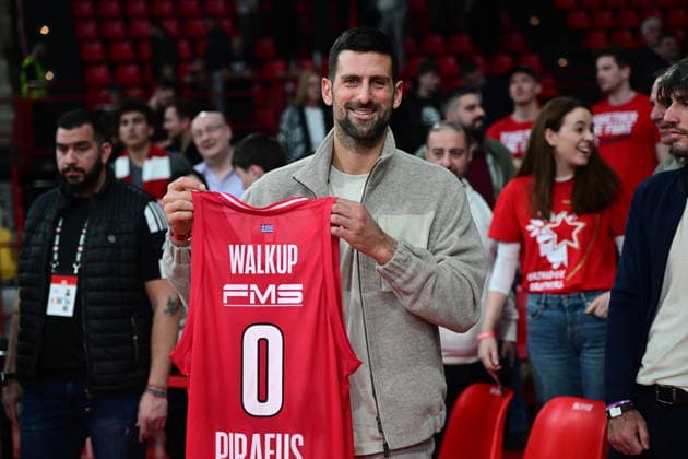 EuroLeague Basketball, Olympiacos Piraeus vs Crvena Zvezda Meridianbet Belgrade - Novak Djokovic, Serbian professional tennis player, react holding Thomas Walkup, 0 of Olympiacos Piraeus jersey at the end of the Euroleague regular season basketball match between Olympiacos Piraeus and Crvena Zvezda Meridianbet Belgrade held at Peace and Friendship Stadium in Piraeus, Grecee, 13 February 2026. PIRAEUS Greece Copyright: xOnexInchxProductionsx 6849800