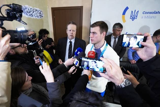 Milan Cortina Olympics: Disqualified Ukrainian athlete Ukrainian skeleton racer Vladyslav Heraskevych (C) is surrounded by journalists following a press conference, PK, Pressekonferenz in Milan on Feb. 12, 2026, after he was disqualified from the Milan Cortina Olympics for refusing to give up his plan to race in a helmet commemorating athletes killed since Russia s invasion.  A14AA0005277716P