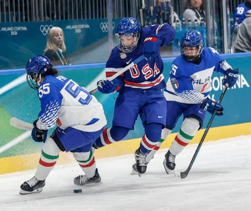 United States Cayla Barnes (3) maneuvers between Italy s Jacquie Pierri (55) and Italy s Greta Niccolai (15) during the Women s Playoff Quarterfinal game between Italy and the USA at the Milano Rho Ice hockey, Eishockey Arena in Milan, Italy, on Friday, February 13, 2026.  OLY202602138608 AARONxJOSEFCZYK