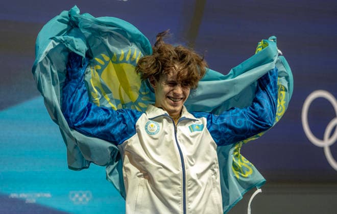 February 14, 2026, Milan, Lombardy, Italy: Kazakhstans MIKHAIL SHAIDOROV takes the gold medal and celebrates with his flag in the kiss and cry area in menÃ¢â‚¬â ¢s Figure skating, Eiskunstlauf Friday at the Milano Ice Skating Arena during this Milano Cortina 2026 Olympics. Olympics 2026: Milano Cortina: Figure Skating Men s  - ZUMAa35_ 20260214_oly_a35_016 Copyright: xDanielxA.xAndersonx