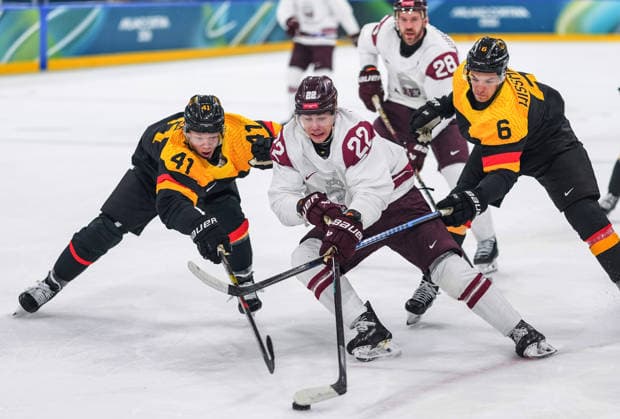 (260214) -- MILAN, Feb. 14, 2026 -- Sandis Vilmanis (2nd L) of Latvia and Jonas Muller (1st L) of Germany battle for the puck during the Ice hockey, Eishockey men s preliminary round group C match between Germany and Latvia of the Milan-Cortina 2026 Olympic Winter games, Winterspiele,Spiele, Summer games in Milan, Italy, Feb. 14, 2026. ) (MICO2026)ITALY-MILAN-OLYMPIC WINTER GAMES-ICE HOCKEY-MEN-PRELIMINARY-GER VS LAT SunxFei 