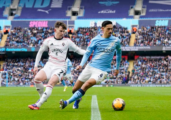 Manchester, England, 14th February 2026. Ben Woodburn of Salford City tussles with Tijjani Reijnders of Manchester City during the Manchester City vs Salford City FA Cup fourth round match at the Etihad Stadium, Manchester. Picture credit should read: Andrew Yates Sportimage EDITORIAL USE ONLY. No use with unauthorised audio, video, data, fixture lists, club league logos or live services. Online in-match use limited to 120 images, no video emulation. No use in betting, games or single club league player publications. SPI_017_AY_Man_City_Salford SPI-4533-0017
