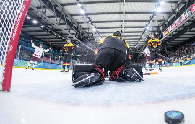 (260214) -- MILAN, Feb. 14, 2026 -- Dans Locmelis (1st L) of Latvia scores during the Ice hockey, Eishockey men s preliminary round group C match between Germany and Latvia of the Milan-Cortina 2026 Olympic Winter games, Winterspiele,Spiele, Summer games in Milan, Italy, Feb. 14, 2026. ( Pool via Xinhua) (MICO2026)ITALY-MILAN-OLYMPIC WINTER GAMES-ICE HOCKEY-MEN-PRELIMINARY-GER VS LAT SunxFei 