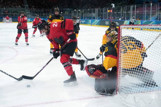 February 14, 2026, Milan, ITALY: Canada s Natalie Spooner (24) digs for the puck in front of Germany goalie Sandra Abstreiter during the first period of a women s hockey quarterfinal game at the 2026 Winter Olympics, in Milan, Saturday, Feb. 14, 2026. Canada News - February 14, 2026  - ZUMAc35_ 20260214_zaf_c35_013 Copyright: xDarrylxDyckx
