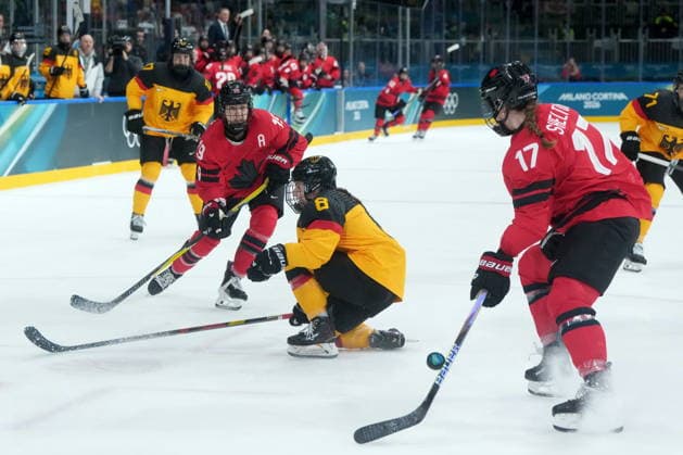 February 14, 2026, Milan, ITALY: Canada s Brianne Jenner (19) passes to teammate Ella Shelton (17) past Germany s Ronja Hark (8) during the first period of a women s hockey quarterfinal game at the 2026 Winter Olympics, in Milan, Saturday, Feb. 14, 2026. Canada News - February 14, 2026  - ZUMAc35_ 20260214_zaf_c35_016 Copyright: xDarrylxDyckx