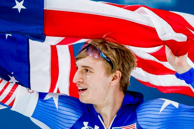 Jordan Stolz of United States of America celebrating and holding flag after Men s 500m, Milano Cortina 2026 Winter Olympics: Day 8, Speed skating, Eisschnelllauf - Milano Cortina 2026 Winter Olympics: Day 8, Milano Speed Skating Stadium, February 14, 2026, Milan, Italy.
