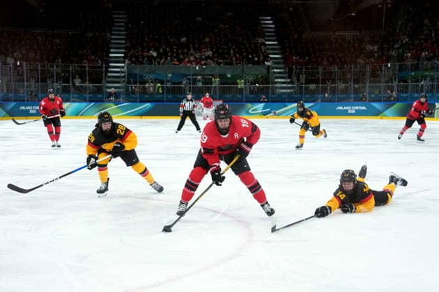 February 14, 2026, Milan, ITALY: Canada s Brianne Jenner (19) passes avoiding the check from Germany s Carina Strobel (14) during the second period of a women s hockey quarterfinal game at the 2026 Winter Olympics, in Milan, Saturday, Feb. 14, 2026. Germany s Katarina Jobst-Smith (28) looks on. Canada News - February 14, 2026  - ZUMAc35_ 20260214_zaf_c35_032 Copyright: xDarrylxDyckx