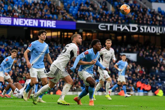 Manchester City v Salford City, FA Cup Ryan McAidoo (56) of Manchester City heads the ball under pressure from Brandon Cooper (15) of Salford City during the FA Cup match between Manchester City and Salford City at the Etihad Stadium, Manchester, UK on 14 February 2026. Manchester Etihad Stadium Manchester UK Editorial use only DataCo restrictions apply See www.football-dataco.com , Copyright: xConorxMolloyx PSI-23752-0062
