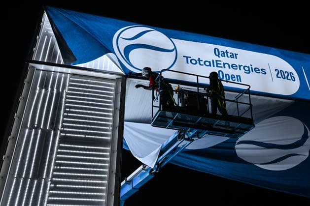 Doha Racket Exchange: WTA, Tennis Damen 1000 Finale Gives Way To ATP, Tennis Herren 500 Arrivals DOHA, QATAR - FEBRUARY 14: Maintenance crews use a hydraulic lift to dismantle a large WTA 1000 entrance banner on the final night of the 2026 Qatar TotalEnergies Open at the Khalifa International Tennis and Squash Complex in Doha, Qatar, February 14, 2026. The evening marks a major logistical transition at the venue as the WTA 1000 event concludes and the site prepares for the arrival of the ATP 500 tour with early practice sessions and media preparations already underway. Doha Qatar  Copyright: xArturxWidakx originalFilename:widak-doharack260214_nphVy.jpg