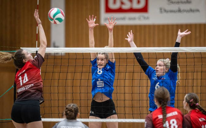 Volleyball, Saison 2025 2026, Dritte Liga West, 14.02.2026, 16. Spieltag, Frauen, BW Dingden (blau) vs. VV Humann Essen (rot) v.l.: Lisa Mueller (VV Humann Essen), Janne Epping (BW Dingden), Louisa Baumeister (BW Dingden), Hamminkeln Sporthalle am Mumbeckerbach Nordrhein-Westfalen Deutschland