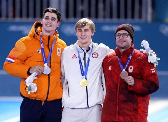 Milan Cortina Olympics: Speed skating, Eisschnelllauf American speed skater Jordan Stolz (C) poses after winning gold in the men s 500 meters at the Milan Cortina Olympics at Milano Speed Skating Stadium in Milan on Feb. 14, 2026, alongside silver medalist Jenning de Boo (L) of the Netherlands and bronze medalist Laurent Dubreuil of Canada.  A14AA0005286335P