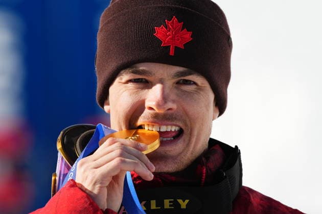 February 15, 2026, Livigno, Italy: Canada s Mikael Kingsbury bites into his gold medal as he celebrates winning the men s freestyle skiing dual moguls at the 2026 Winter Olympics, in Livigno, Italy, Sunday, Feb. 15, 2026. Canada News - February 15, 2026  - ZUMAc35_ 20260215_zaf_c35_027 Copyright: xSeanxKilpatrickx