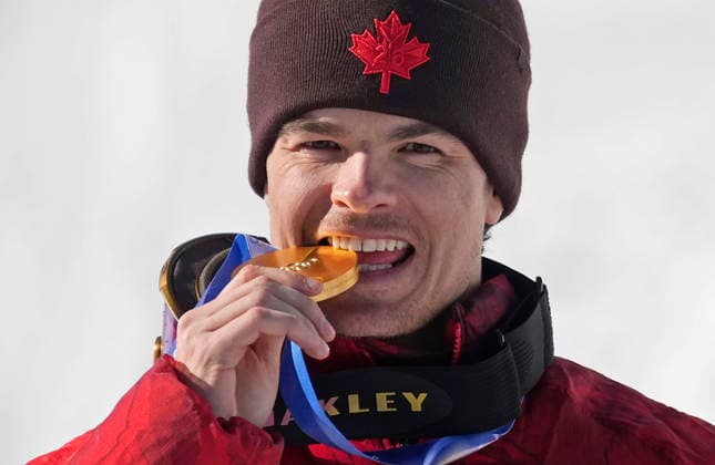 Gold medalist Mikael Kingsbury of Canada poses with his medal after the Men s Freestyle Skiing Dual Moguls competition at the Milano Cortina 2026 Winter Olympic Games, Olympische Spiele, Olympia, OS in Livigno, Italy, on Sunday, February 15, 2026. Ikuma Horishima of Japan won the silver medal and Matt Graham of Australia won the bronze medal.  OLY20260215819 BOBxSTRONG