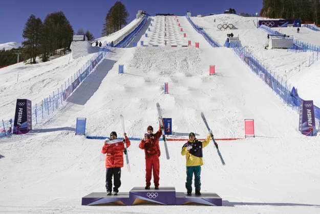 Gold medalist Mikael Kingsbury of Canada (C), silver medalist Ikuma Horishima of Japan (L) and bronze medalist Matt Graham of Australia pose on the podium after the Men s Freestyle Skiing Dual Moguls competition at the Milano Cortina 2026 Winter Olympic Games, Olympische Spiele, Olympia, OS in Livigno, Italy, on Sunday, February 15, 2026.  OLY20260215850 BOBxSTRONG