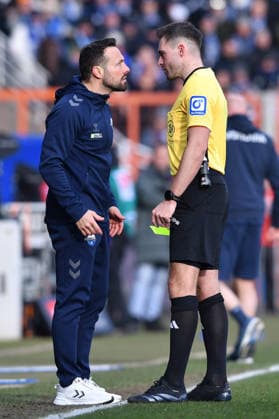 Fußball 2. Bundesliga 22. Spieltag VfL Bochum - SC Paderborn 07 am 15.02.2026 im Vonovia Ruhrstadion in Bochum Schiedsrichter Tom Bauer, rechts - zeigt Ralf Kettemann ( Trainer Cheftrainer Paderborn ), links - die gelbe Karte DFL regulations prohibit any use of photographs as image sequences and or quasi-video.