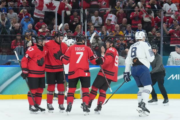 February 15, 2026, Milan, ITALY: Devon Toews (7) of Team Canada celebrates his goal with teammates as Hugo Gallet (8) of Team France skates by during first period Olympic hockey action at the 2026 Milan Cortina Winter Olympics in Milan, Italy on Sunday Feb. 15, 2026. Canada News - February 15, 2026  - ZUMAc35_ 20260215_zaf_c35_071 Copyright: xNathanxDenettex