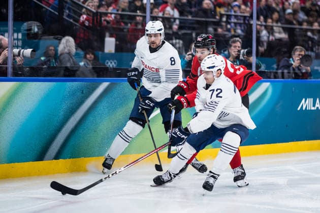 MILANO, ITALY - FEBRUARY 15: Brandon Hagel (Canada, 38) and Jordann Perret (France, 72) battle for the puck during the Ice hockey, Eishockey Men Canada vs France - Preliminary Round - Group A at the Milano Cortina 2026 Olympics at Milano Santagiulia Ice Hockey Arena on day 9 of the Milano Cortina 2026 Olympics on February 15, 2026 in Milano, Italy. Editorial use only. Italy Copyright: xSteffiexWunderlx