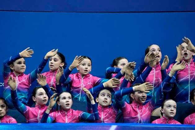 Speed birds, the young girls who pick up the flowers from the ice rink dance along with the music before the Pairs Figure skating, Eiskunstlauf Short Program at the Milano Figure Skating Arena in Milan, Italy on Sunday, February 15, 2026.  OLY20260215100 RichardxEllis