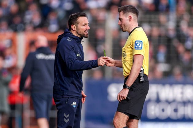 15.02.2026, Fußball, VfL Bochum - SC Paderborn 07, 2. Fußball Bundesliga, 22. Spieltag, Vonovia Ruhrstadion, Saison 2025 2026: Cheftrainer Ralf Kettemann (SC Paderborn hc) gestikulierend am Spielfeldrand neben Schiedsrichter Tom Bauer - Gelbe Karte DFB regulations prohibit any use of photographs as image sequences and or quasi-video. Nordrhein-Westfalen Deutschland