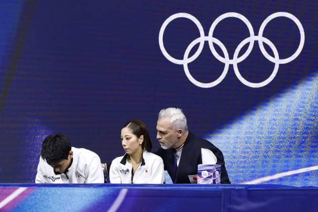 Milan Cortina Olympics: Figure skating, Eiskunstlauf Riku Miura (C) and Ryuichi Kihara (L) of Japan react to their score in the kiss and cry area with their coach Bruno Marcotte after performing in the pairs figure skating short program at the Milan Cortina Olympics at Milano Ice Skating Arena in Milan on Feb. 15, 2026.  A14AA0005291193P