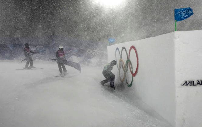 Course workers secure flags during a heavy snowstorm and high winds before the start of the Women s Freeski Big Air Final at the Milano Cortina 2026 Winter Olympic Games, Olympische Spiele, Olympia, OS in Livigno, Italy, on Monday, February 16, 2026.  OLY20260216808 BOBxSTRONG