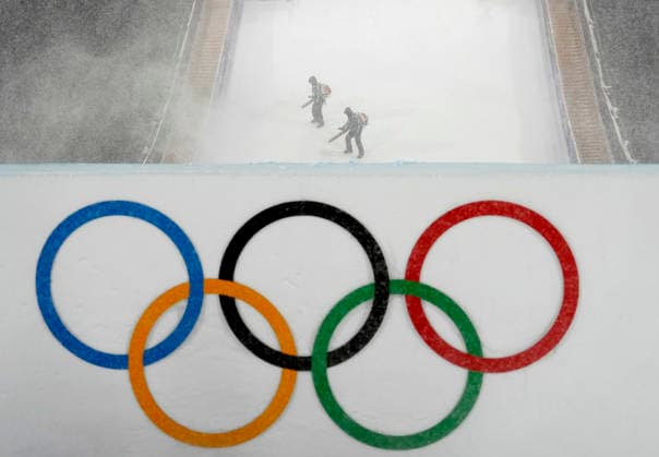 Course workers try to blow snow from the jump during a heavy snowstorm before the start of the Women s Freeski Big Air Final at the Milano Cortina 2026 Winter Olympic Games, Olympische Spiele, Olympia, OS in Livigno, Italy, on Monday, February 16, 2026.  OLY20260216824 BOBxSTRONG