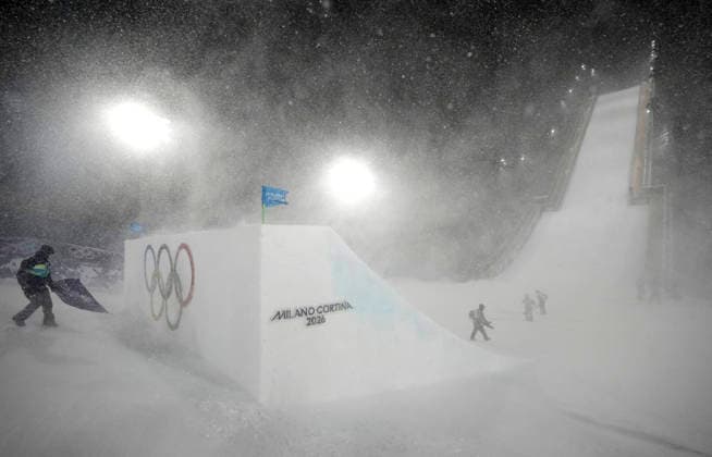 Course workers secure flags and try to clear snow from the jump as heavy snow and high winds delay the start of the Women s Freeski Big Air Final at the Milano Cortina 2026 Winter Olympic Games, Olympische Spiele, Olympia, OS in Livigno, Italy, on Monday, February 16, 2026.  OLY20260216830 BOBxSTRONG