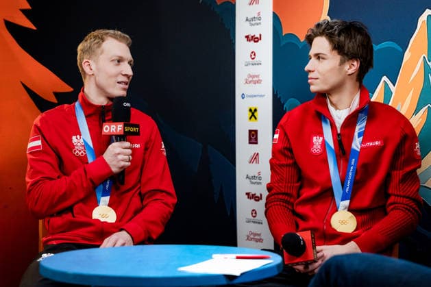 OLYMPICS - Winter Olympic Games, Olympische Spiele, Olympia, OS Milano Cortina 2026 PREDAZZO,ITALY,16.FEB.26 - OLYMPICS, Ski jumping, Skispringen, Ski, nordisch - Winter Olympic Games Milano Cortina 2026, large hill, Super Team, men, reception for medalists. Image shows Jan Hoerl and Stephan Embacher (AUT) during an interview with ORF.  GEPAxpictures xMatthiasxTrinkl