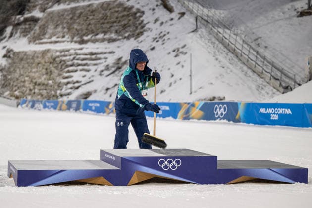 OLYMPICS - Winter Olympic Games, Olympische Spiele, Olympia, OS Milano Cortina 2026 PREDAZZO,ITALY,16.FEB.26 - OLYMPICS, Ski jumping, Skispringen, Ski, nordisch - Winter Olympic Games Milano Cortina 2026, large hill, Super Team, men. Image shows photo manager Arnt Folvik (NOR) cleaning the podest from the fresh snow.  GEPAxpictures xOliverxLerch