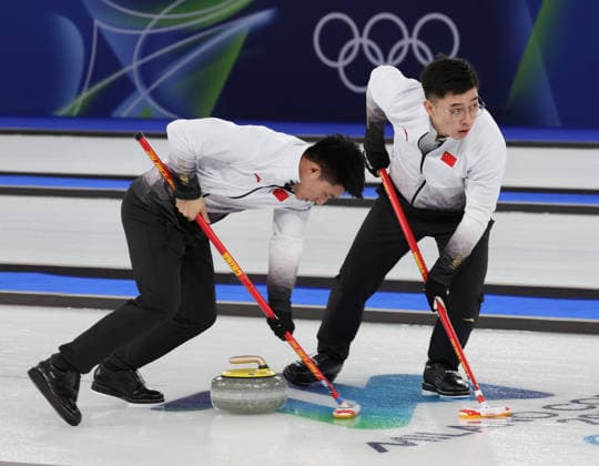 China s Xuequing Wei and Li Zhichao polish the ice in their match against USA in the Round Robin Team Curling match at the 2026 Winter Olympics in Cortina, Italy on Tuesday February 17, 2026. China won the match 8-5.  OLY20260217606a HUGOxPHILPOTT