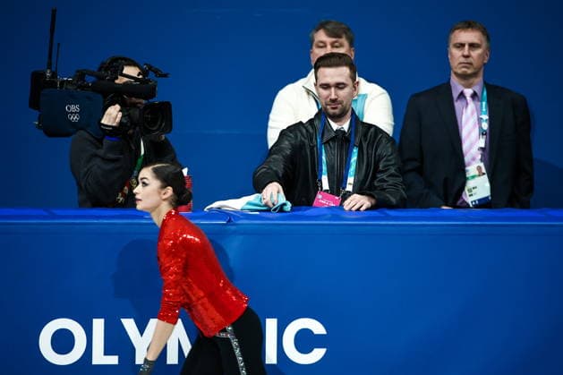 ITALY, MILAN - FEBRUARY 17, 2026: AIN athlete Adeliia Petrosian from Russia (front) and Russian coach Daniil Gleikhengauz (C midground) during the women s singles short programme at the 2026 Winter Olympic Games, Olympische Spiele, Olympia, OS at Milano Ice Skating Arena. Mikhail Tereshchenko TASS  88859371