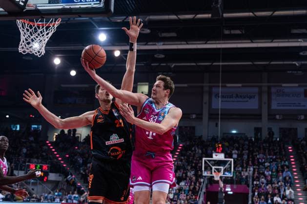 Spielaktion mit Patrick Heckmann (33; Telekom Baskets Bonn) in magentafarbenem Trikot im Spiel zwischen Telekom Baskets Bonn und RASTA Vechta am 21. Spieltag der EasyCredit BBL in Bonn. Patrick Heckmann (33; Telekom Baskets Bonn) mit Wurf gegen Tibor Pleiss (22; RASTA Vechta)
