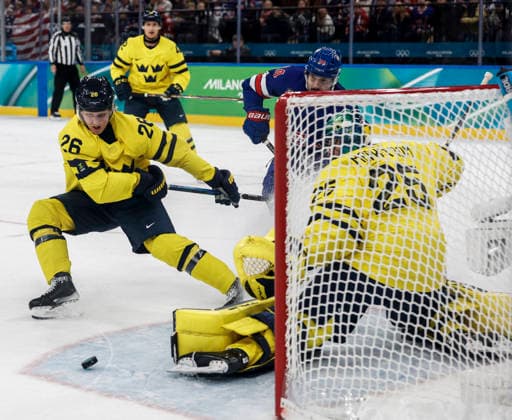 Sweden s Rasmus Dahlin (26) and Sweden s Jacob Markstrom (25) deflects a shot on goal in the first period of the Men s Hockey Playoff Quarter-final game between Sweden and the USA at the Milano Santagiulia Ice hockey, Eishockey Arena in Milan, Italy, on Wednesday, February 18, 2026.  OLY20260218316 AARONxJOSEFCZYK