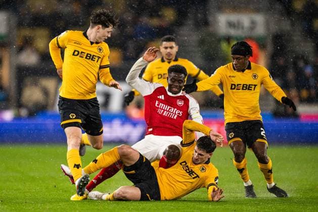 18th February 2026; Molineux Stadium, Wolverhampton, West Midlands, England; Premier League Football, Wolverhampton Wanderers versus Arsenal; Bukayo Saka of Arsenal is tackled by Matt Doherty of Wolverhampton Wanderers with Ladislav Krejci and Jean Ricner Bellegarde in close attendance  GodfreyxPitt Content restricted for UK based newspaper