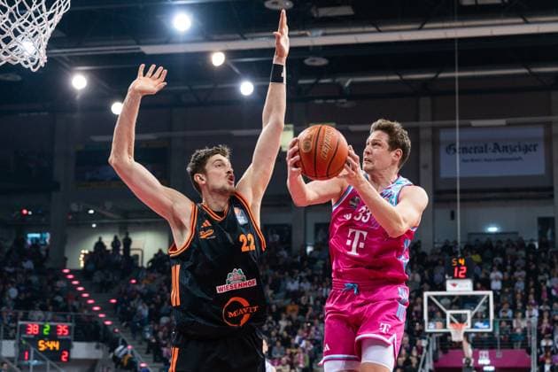 Spielaktion mit Patrick Heckmann (33; Telekom Baskets Bonn) und Tibor Pleiss (22; Rasta Vechta) im Spiel zwischen Telekom Baskets Bonn und RASTA Vechta am 21. Spieltag der EasyCredit BBL in Bonn. Patrick Heckmann (33; Telekom Baskets Bonn) mit Wurf gegen Tibor Pleiss (22; Rasta Vechta)