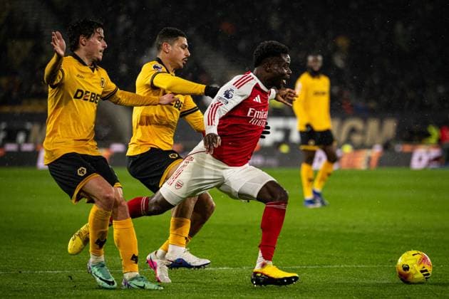 18th February 2026; Molineux Stadium, Wolverhampton, West Midlands, England; Premier League Football, Wolverhampton Wanderers versus Arsenal; Bukayo Saka of Arsenal runs past Hugo Bueno and Andre of Wolverhampton Wanderers  GodfreyxPitt Content restricted for UK based newspaper